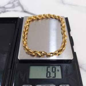 6.9g 18K yellow gold twisted chain bracelet 8 inches on a scale